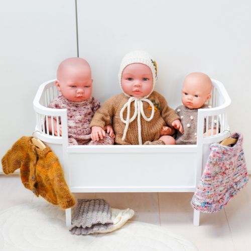 dukker sidder i dukkeseng med nyt dukketøj på